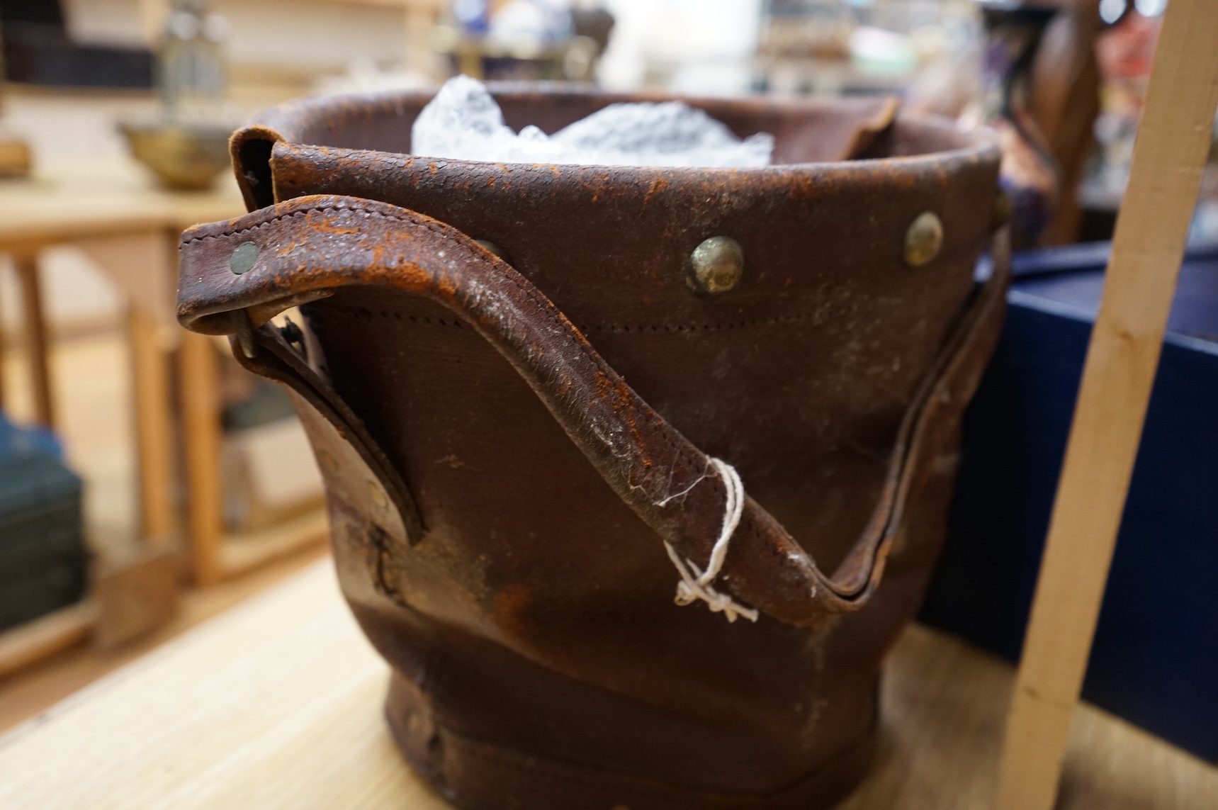 A brown leather fire bucket with Royal Coat of Arms decoration, 25cm high